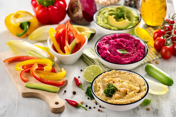 Colorful hummus with vegetables, vegan snack, beetroot and avocado hummus, vegetarian eating