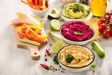 Colorful hummus with vegetables, vegan snack, beetroot and avocado hummus, vegetarian eating