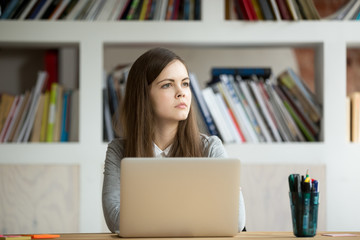 Concentrated female worker looking away thinking about problem solution and project success...
