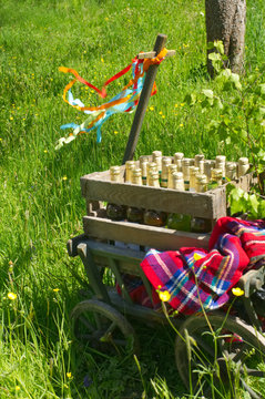 A handcart with a blanket, a beer box, colorful ribbons on a wonderful spring meadow for fathers day