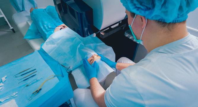 Laser vision correction. A patient and team of surgeons in the operating room during ophthalmic surgery. Eyelid speculum. Lasik treatment.