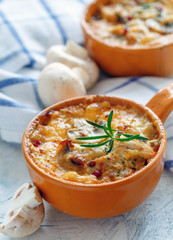 Roasted mushrooms, chicken and cheese gratin in pan.