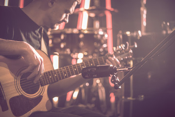 The Studio microphone records an acoustic guitar close-up. Beautiful blurred background of colored...