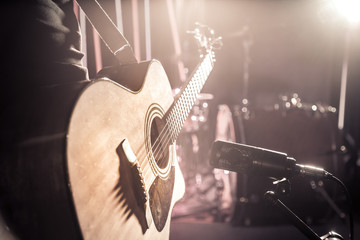 The Studio microphone records an acoustic guitar close-up. Beautiful blurred background of colored...