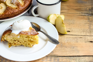 Apple cake on the plate with ice cream and milk on a wooden table. Selective focus