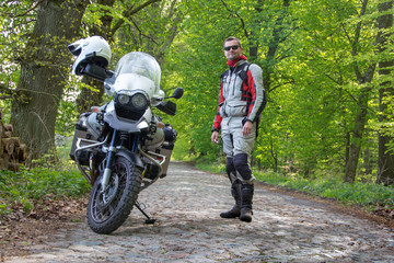 Reiseenduro Motorrad im Wald mit Fahrer - Blick in die Ferne - obrazy, fototapety, plakaty
