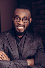 Cheerful nice businessman standing cross handed