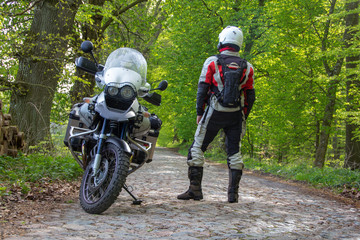 Reiseenduro Motorrad im Wald mit Fahrer - Blick zurück