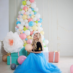Beautiful young blonde with balloons. Colorful balls.