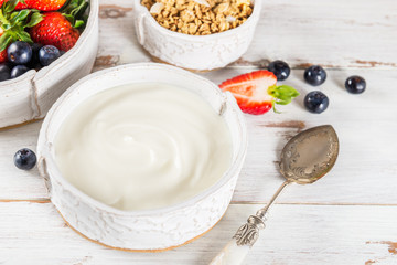 Bowl of natural yogurt with granola and fresh berries