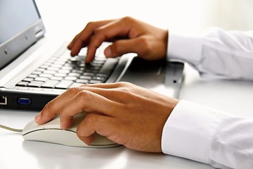hand with mouse on PC keyboard on table