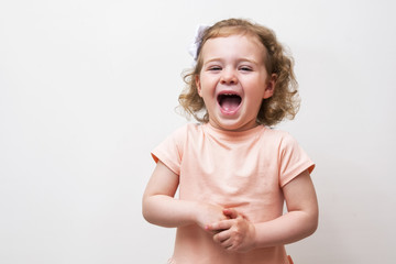 Adorable little baby girl laughing and playing in the studio, isolated on white background