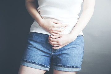 Woman with menstrual pain is holding her aching belly