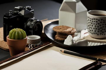 BlaTable set with coffee,  camera and note pad with empty space fot writing