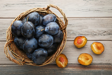 Ripe and sweet plums in basket on wooden table © 5second