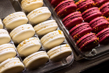 French desert, fresh colorful macarons in the bakery, white and pink colors