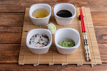 Japanese spices. Wasabi, soy sauce, salt and spices on a bamboo mat.