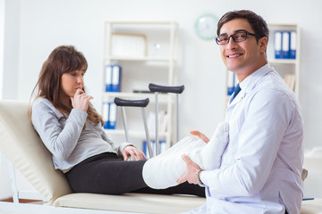 Fototapeta premium Doctor examining patient with broken leg
