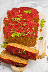 Vegetarian lentil casserole with vegetables and tomato sauce on a wooden board, vertical, white background. Healthy vegan food concept.