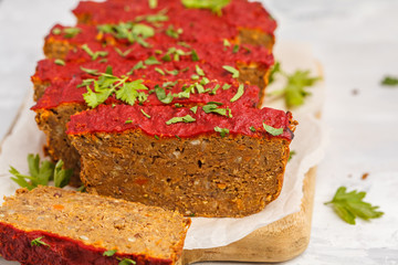 Vegetarian lentil casserole with vegetables and tomato sauce on a wooden board, white background. Healthy vegan food concept.
