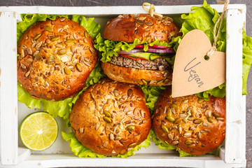 Vegan bean burger with vegetables and tomato sauce in a white wooden box, top view. Healthy vegan...