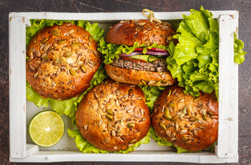 Vegan bean burger with vegetables and tomato sauce in a white wooden box, top view. Healthy vegan food concept.
