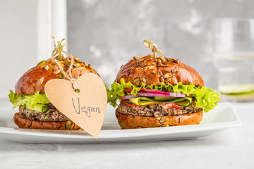 Vegan bean burgers with vegetables and tomato sauce on white dish, copy space. Healthy vegan food...