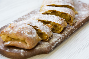 Apple strudel on wooden board. Closeup.