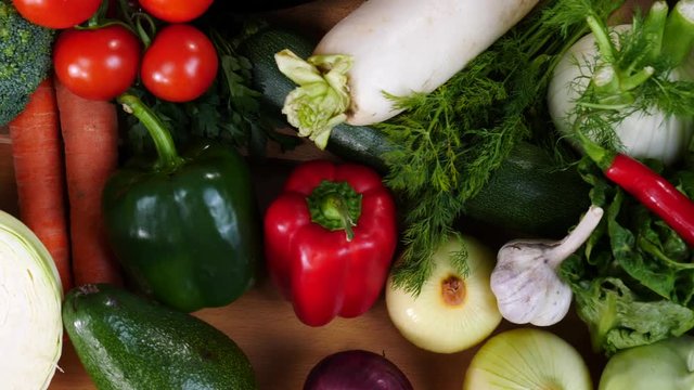 Close up of various healthy vegetables captured in slow motion on kitchen table. Natural dieting food concept.