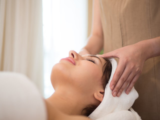 Fototapeta na wymiar Masseur doing massage the head of an woman in the spa salon