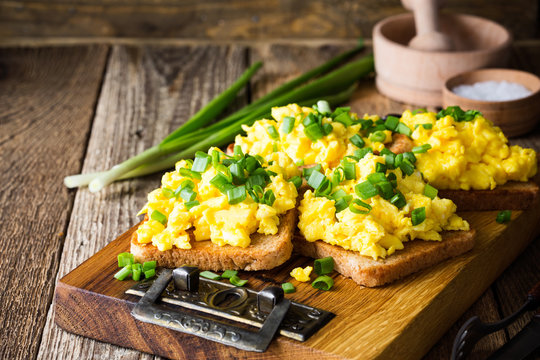 Scrambled eggs with green onion on toasts