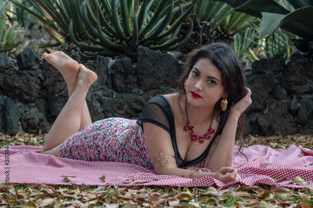 Wall mural stunning and mysterious latina woman laying on the ground