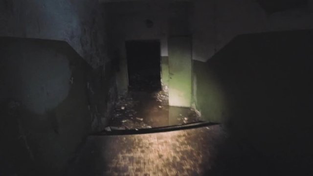 Moving through dark creepy corridor. First person view, going with flashlight in dirty grungy abandoned building, horror escape concept, toned