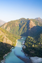 Wonderful green peaks of some mountains with the Ganges river flowing between them in Rishikesh, India