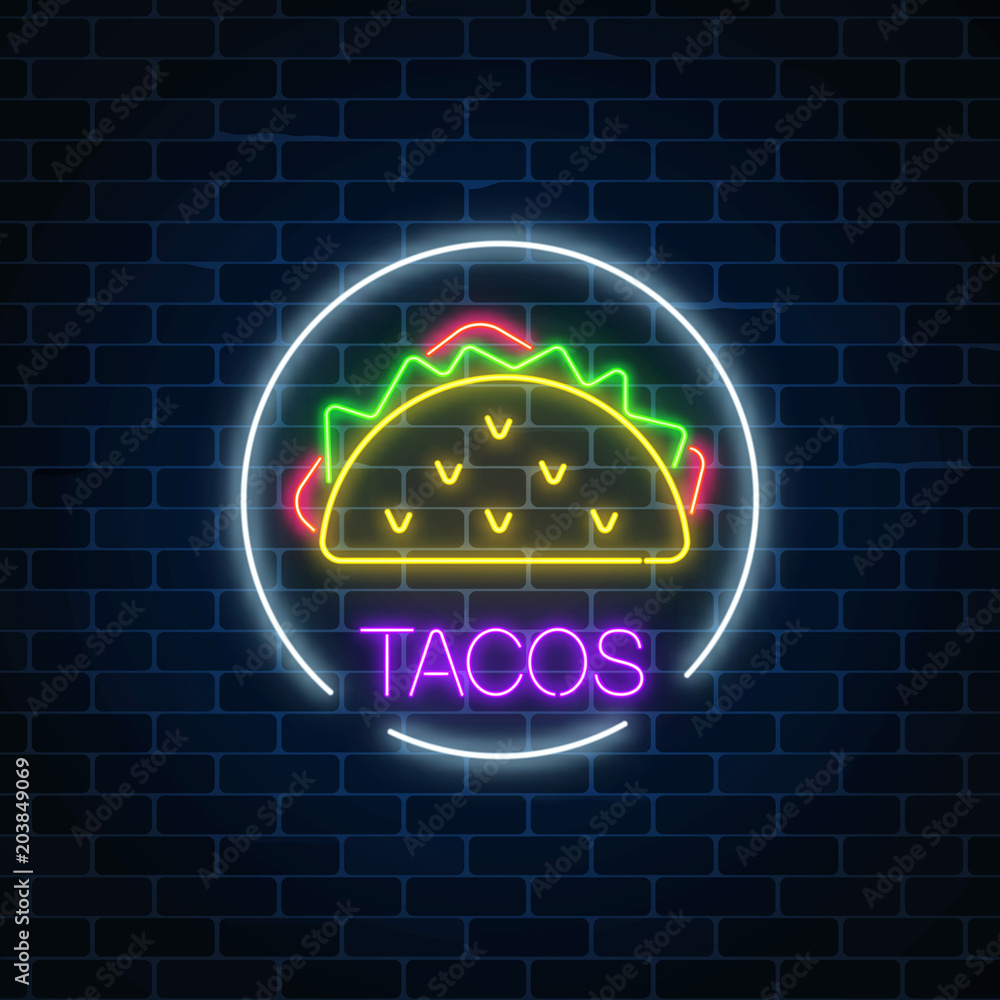 Wall mural Neon glowing sign of tacos in circle frame on a dark brick wall background. Fastfood light billboard symbol.