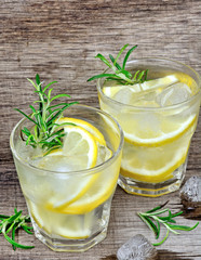Detox water with sliced lemon and rosemary in a glasses on table