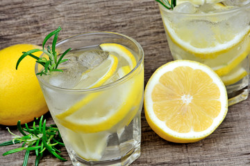 Detox water with sliced lemons and rosemary in a glasses. Refreshing cold summer drink