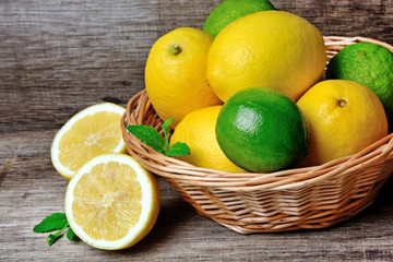 Fototapeta na wymiar Fresh lime and lemon in a basket on a rustic wood table
