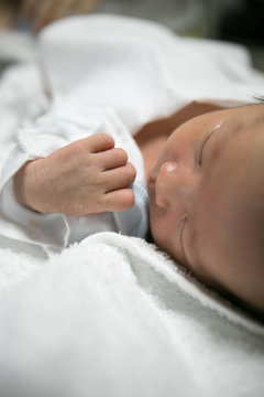 生まれたばかりの新生児の手と顔