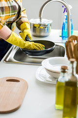 cropped image of woman washing frying pan in kitchen