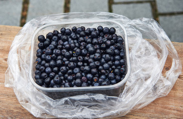 Plastic basin full of blueberries.