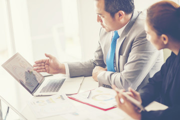 Image of two young businessmen using touchpad at meeting