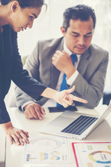 Image of two young businessmen using touchpad at meeting