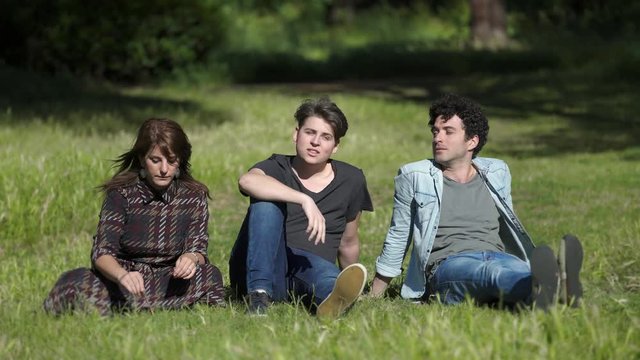 portrait of Young careless friends on the lawn sing, laugh and have fun