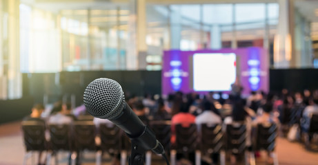 Microphone over the Abstract blurred photo of conference hall or seminar room with Speakers on the stage and attendee background, Business meeting concept