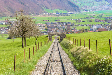 Trees and railway on the foot of Mt. Stanserhorn in Switzerland in the beginning of May. Mt. Stanserhorn is a mountain located in the Swiss canton of Nidwalden, near the town of Stans. © navintar