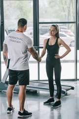  rear view of male personal trainer and young sportswoman shaking hands at gym © LIGHTFIELD STUDIOS