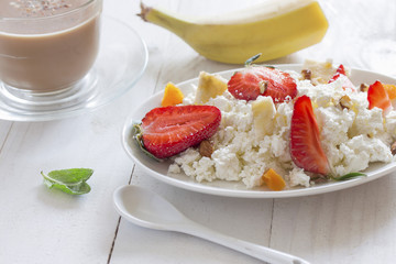 delicious breakfast of cottage cheese with ripe strawberries and fruits