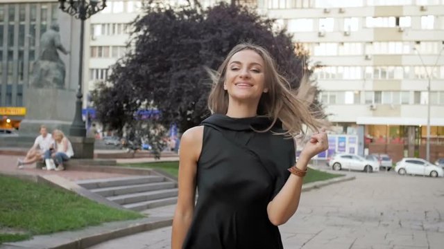 Slow motion video of happy young woman jumping and walking in park