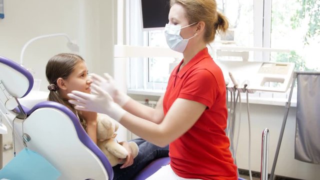 4k footage of female dentist inspecting teenager girl teeth